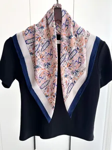 Detail of paisley print cotton linen scarf draped over a black shirt with silk finish