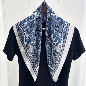Detail of blue and white paisley silk scarf with elegant floral patterns on a shirt