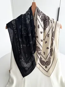 Detail showing classic paisley pattern on light cotton linen scarves in black and beige
