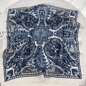 Detailed view of square silk scarf with vintage navy paisley patterns and smooth texture