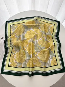 Détail d'un foulard carré élégant à fleurs de pivoine jaune avec bordure géométrique verte