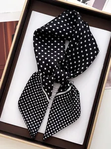 Close-up of a polka dot silk scarf folded in a brown gift box with elegant packaging