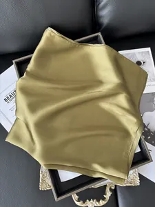 Gros plan sur le foulard carré en satin or olive avec un lustre soyeux et bords roulés