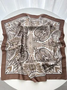 Detailed macro view of vintage paisley patterns on a glossy square silk scarf for women