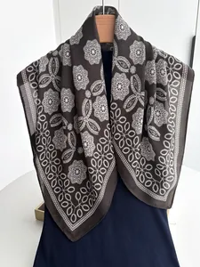 Detail of dark brown cotton linen scarf with white lace floral pattern on blue fabric