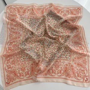 Detail of soft almond paisley silk scarf with orange floral pattern and light chiffon texture
