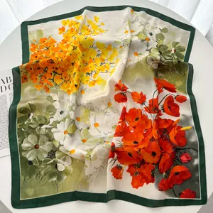 Detailed view of floral print silk scarf featuring yellow and red flowers with green border