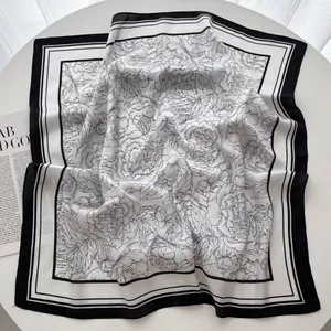Détail d'un élégant foulard en satin de soie noir et blanc au fini brillant haut de gamme