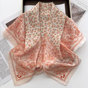 Detailed flat lay of a paisley square silk scarf on an elegant magazine backdrop