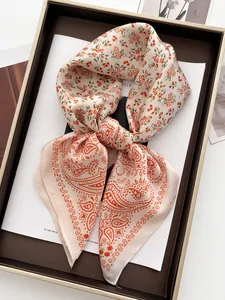 Detailed close-up of pink and orange floral paisley silk scarf tied in a bow