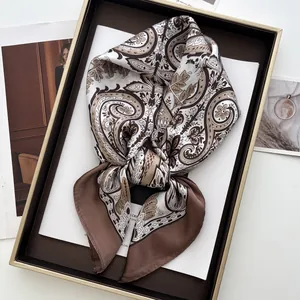Detailed close-up of a vintage paisley silk square scarf folded in a luxury gift box