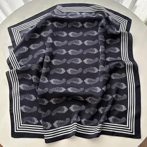 Close-up of silk scarf with classic black and white paisley pattern and striped borders
