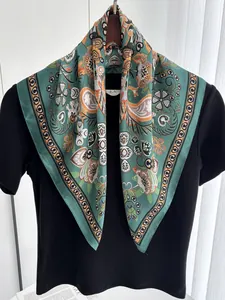 Detail of vintage paisley silk scarf with turquoise, orange motifs and geometric border