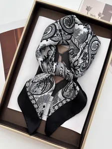Detailed close-up of a vintage paisley print silk scarf with classic black and white patterns