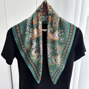 Detail of vintage paisley print silk scarf in emerald green on clothing hanger
