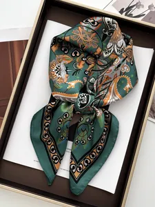 Detail of vintage paisley silk scarf neatly folded in an elegant gift box with magazine decor