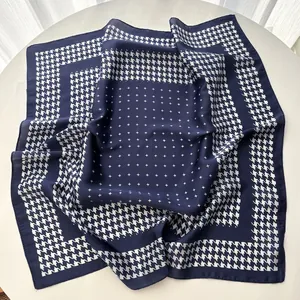 Detailed view of silky navy houndstooth scarf with star pattern on a white table