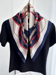 Détail d'un carré de soie élégant avec motifs de ceintures et chaînes sur cintre