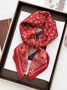 Close-up of luxury red floral silk scarf with paisley pattern in a display box