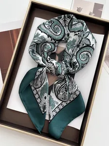 Close-up of a vintage paisley print satin square scarf with silky texture on a tray