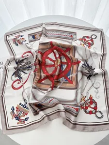 Close-up of nautical silk scarf with anchor and rope patterns on a white table