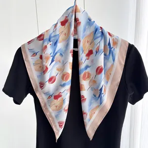Dettaglio di foulard in seta con stampa tulipani acquerello e bordo rosa su maglia nera