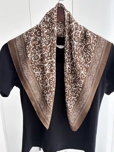 Detailed macro view of the coffee brown silk scarf with white paisley vine pattern