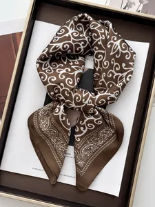 Detail view of coffee brown silk satin scarf with white paisley and scroll patterns