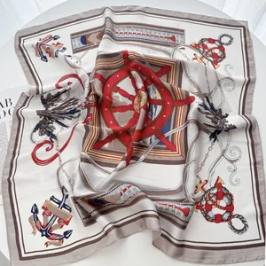 Nautical theme silk square scarf with red anchor and helm prints on white tabletop