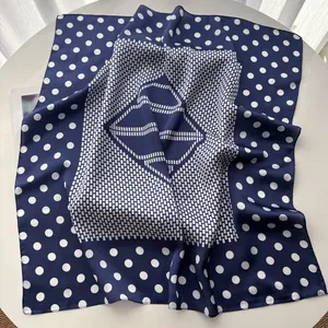 Detailed view of navy blue silk square scarf with white polka dots and geometric patterns