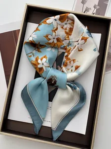 Détail d'un foulard en soie à fleurs avec texture satinée sur un plateau chic