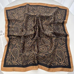 Detail eines luxuriösen Seidenschals mit Paisley- und Blumenmuster in Camel und Schwarz