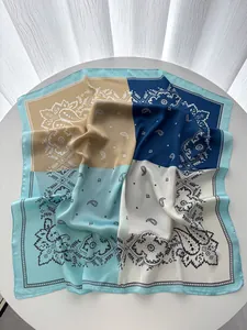 Détail du foulard carré en satin de soie avec motifs paisley et coutures quadricolores