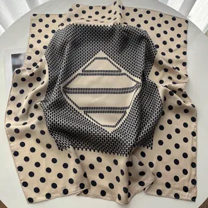Detail of silk-like square scarf featuring beige polka dot patterns and geometric frame