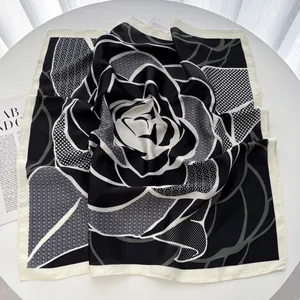 Detailed macro view of black and white checkered floral silk scarf texture and fine hemmed edges