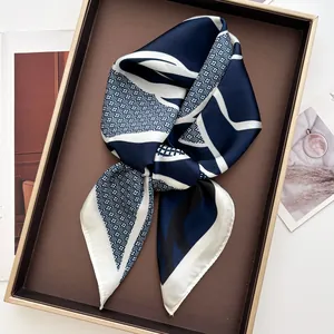 Detail of a chic geometric floral silk scarf folded elegantly in a stylish gift box