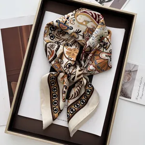 Detail of bohemian paisley silk scarf with vintage prints and stitched edges on a tray