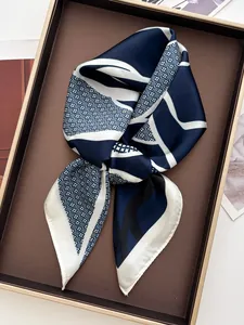 Detailed view of silk-textured small square scarf with navy and beige geometric patterns