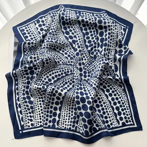 Detail of silk scarf showing white polka dot patterns on navy blue fabric