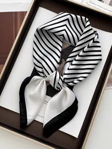 Detail of black and white striped satin scarf with smooth texture in a display tray