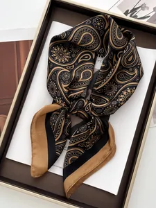 Detail eines luxuriösen Paisley-Seidenschals gefaltet in einer eleganten braunen Geschenkbox