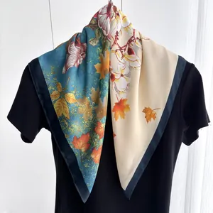Détail d'un carré de soie bicolore avec imprimés floraux et feuilles d'érable élégants