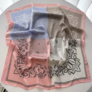 Détail d'un foulard en satin avec motifs paisley et élégants blocs de couleurs variés