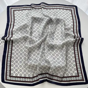 Detailed view of square silk scarf with navy geometric patterns and silky texture