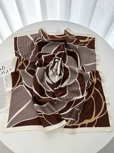 Macro detail of square silk scarf with chocolate rose floral pattern on white table