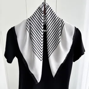 Detail of silk-like neckerchief with black and white geometric stripes on a T-shirt