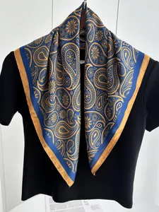 Detailansicht eines luxuriösen dunkelblauen Seidentuchs mit goldenem Paisley-Muster und Rand