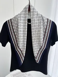 Detailed view of square silk scarf with geometric blue dot pattern and navy red border