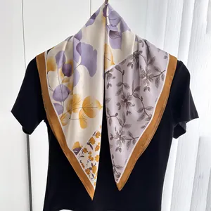 Détail du foulard carré en soie aux motifs botaniques violets et jaunes sur t-shirt noir