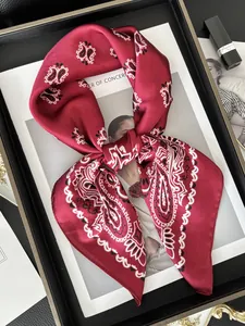 Detail of burgundy paisley silk scarf on a fashion magazine with luxury accessories